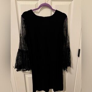 Sheath black dress with lace sleeves.